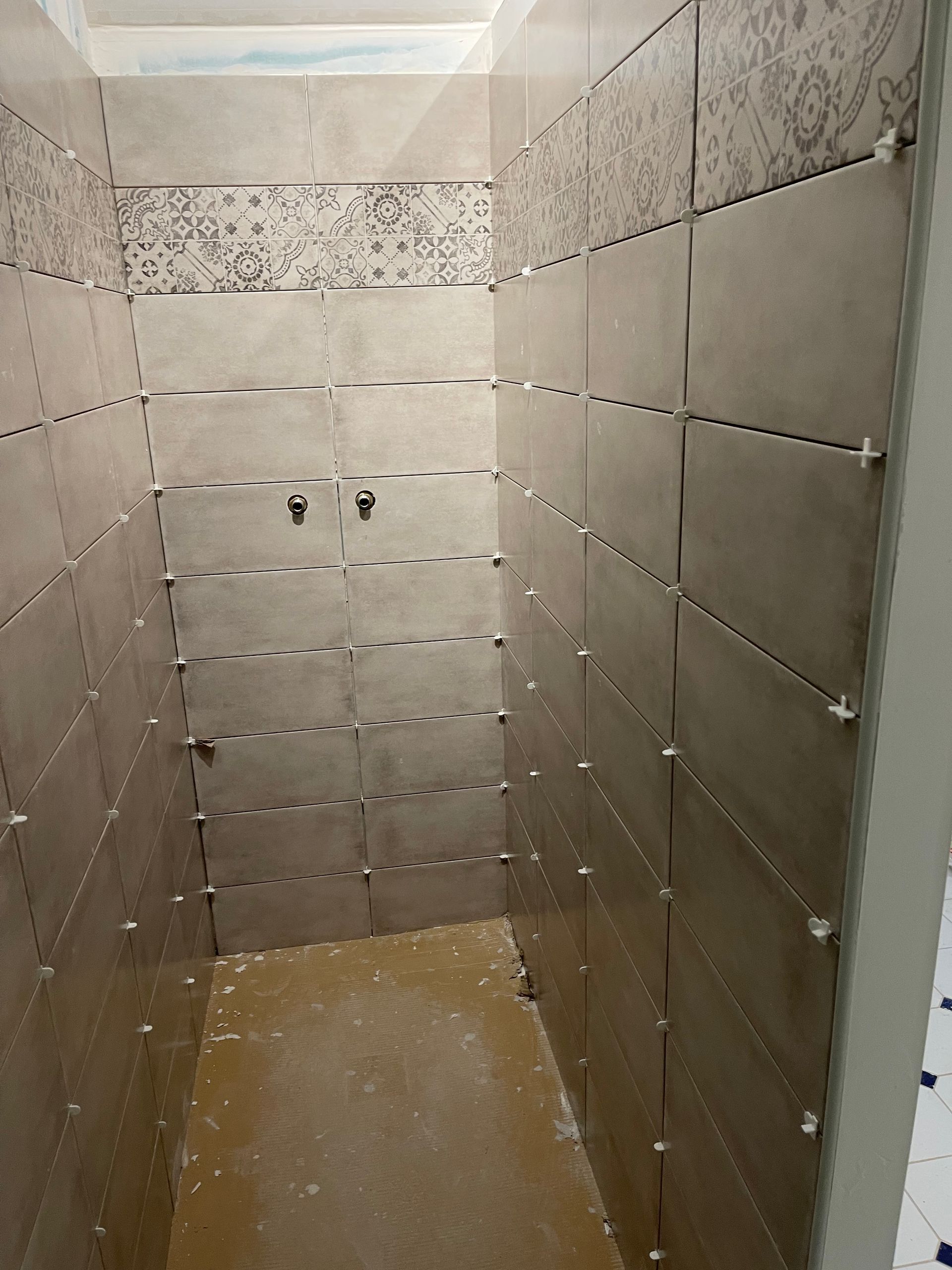 Pose de carrelage mural dans une douche à l'italienne