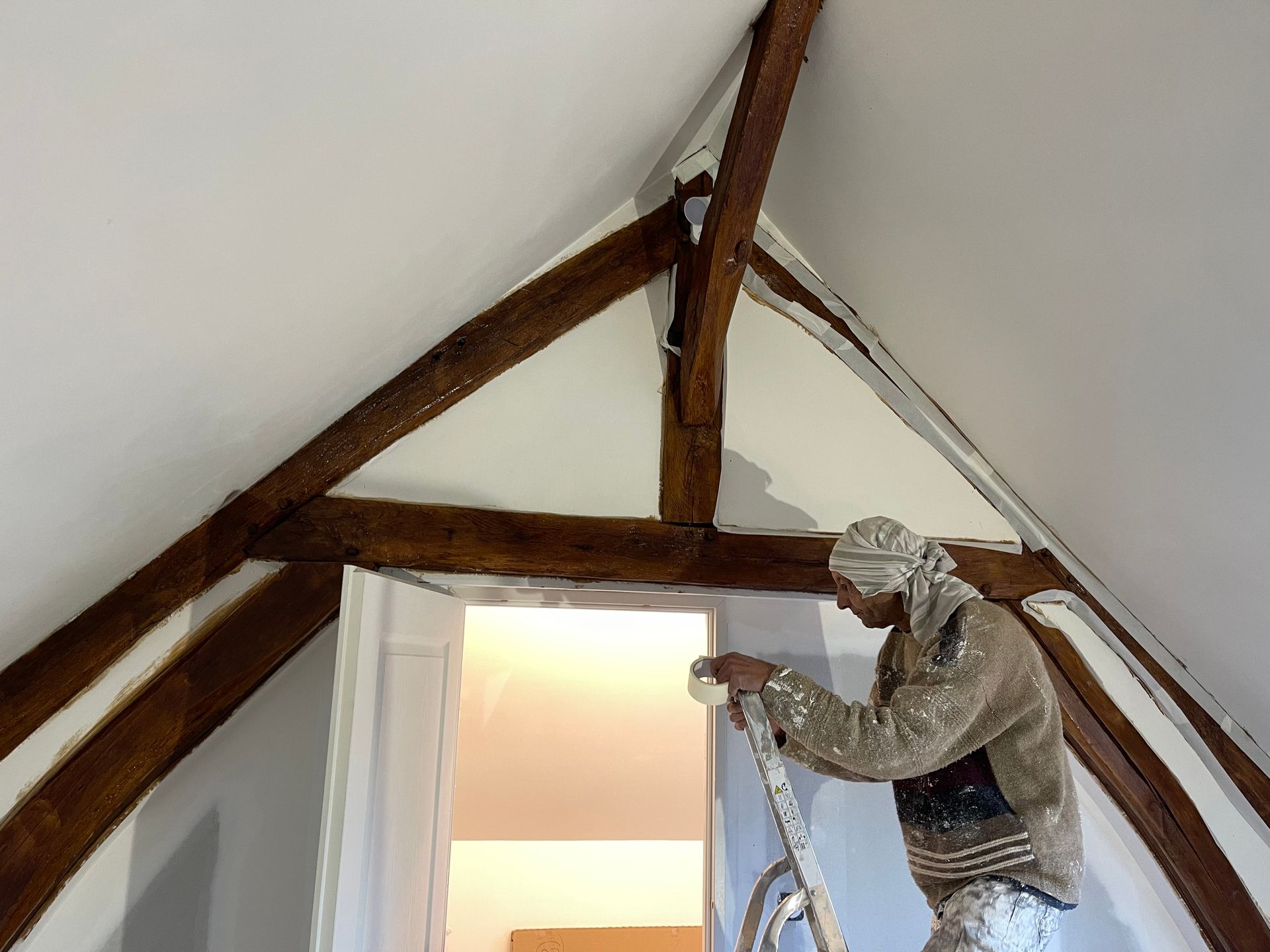 Masquage des poutres apparentes avant peinture du plafond