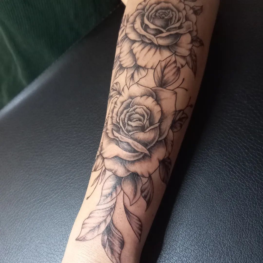 Tatouage réaliste de roses sur un avant-bras