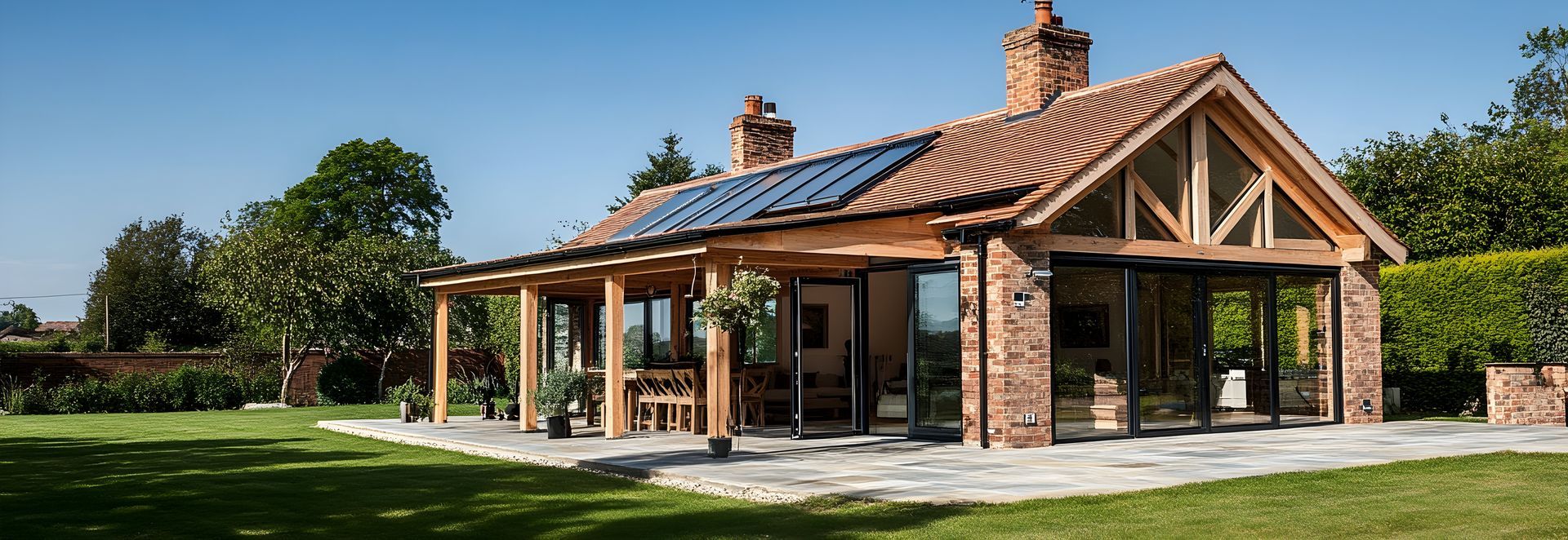 Maison avec des baies vitrées en alu et une pergola