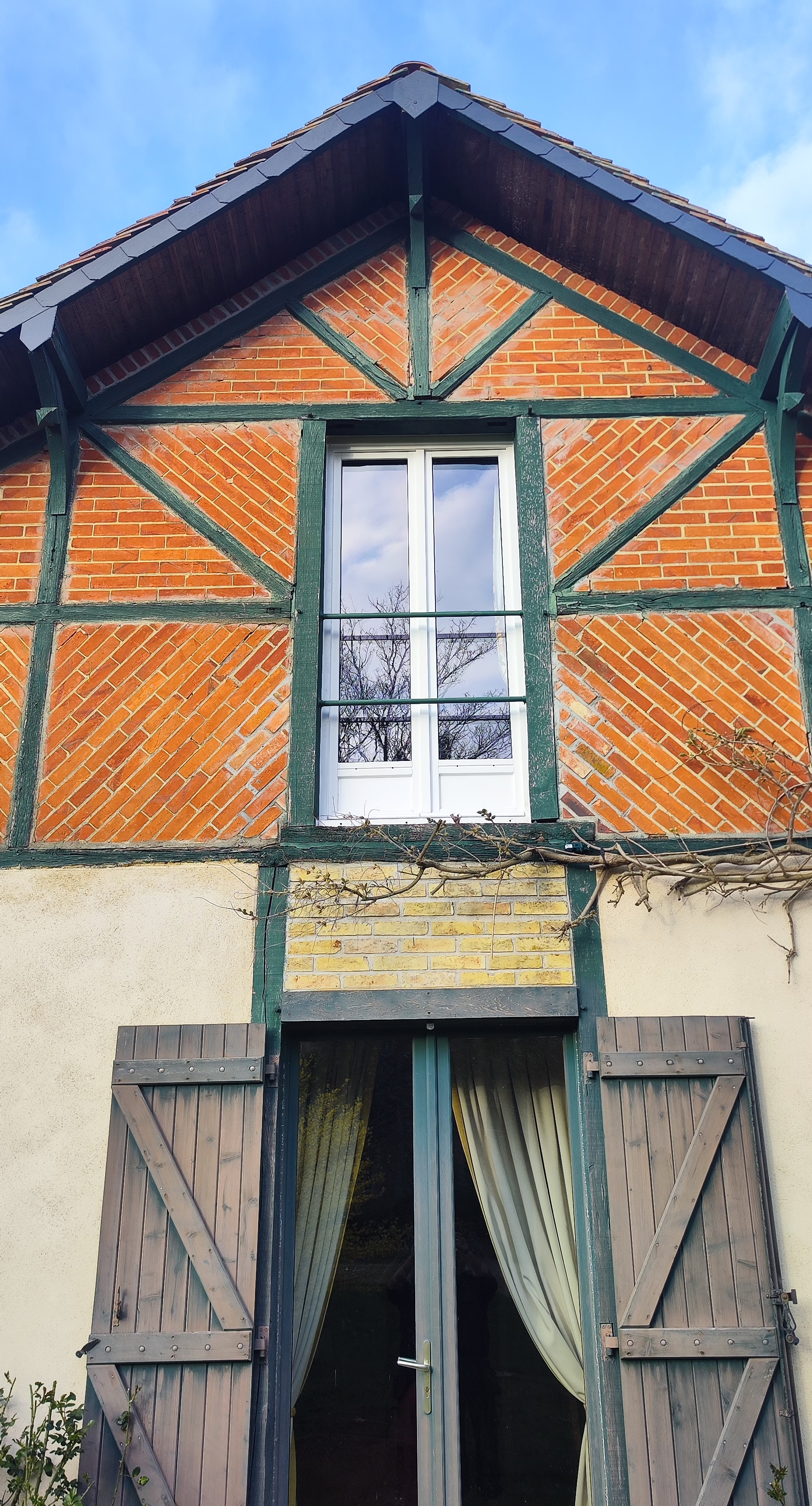 Façade de maison à colombages avec des fenêtres en PVC blanc