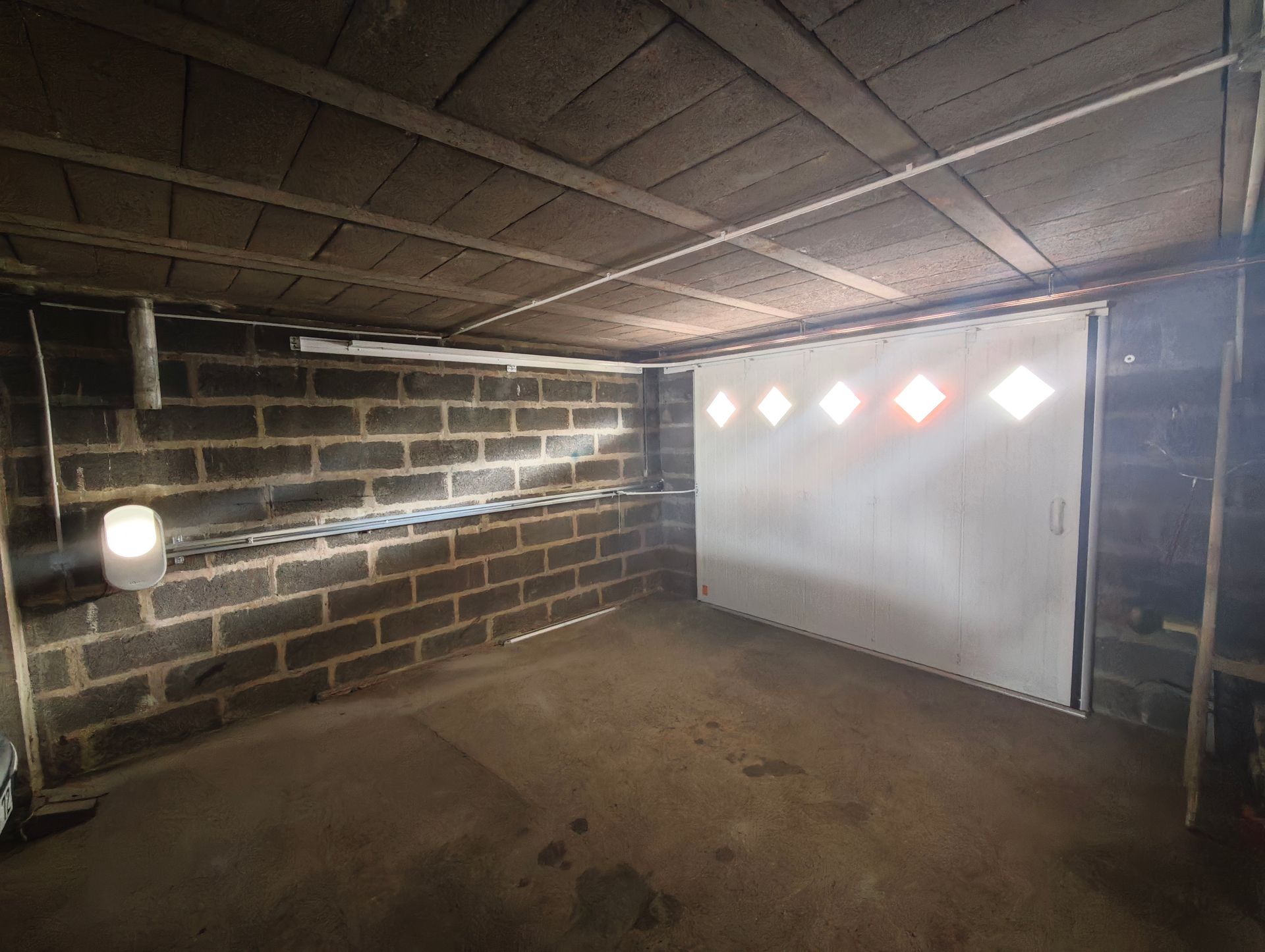 Porte de garage blanche avec des fenêtres vue de l'intérieur du garage