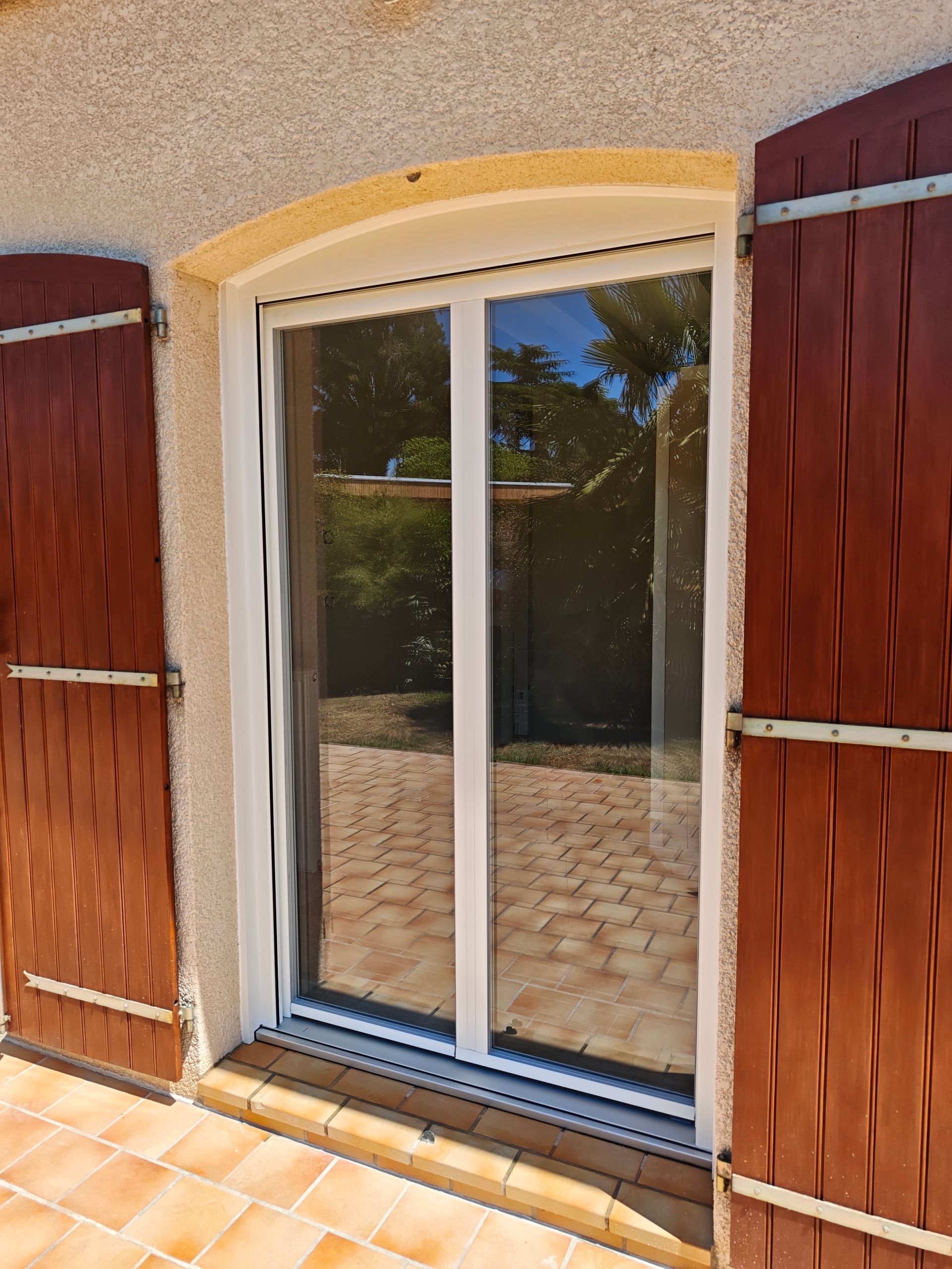 Portes-fenêtres en PVC blanc et volets marron