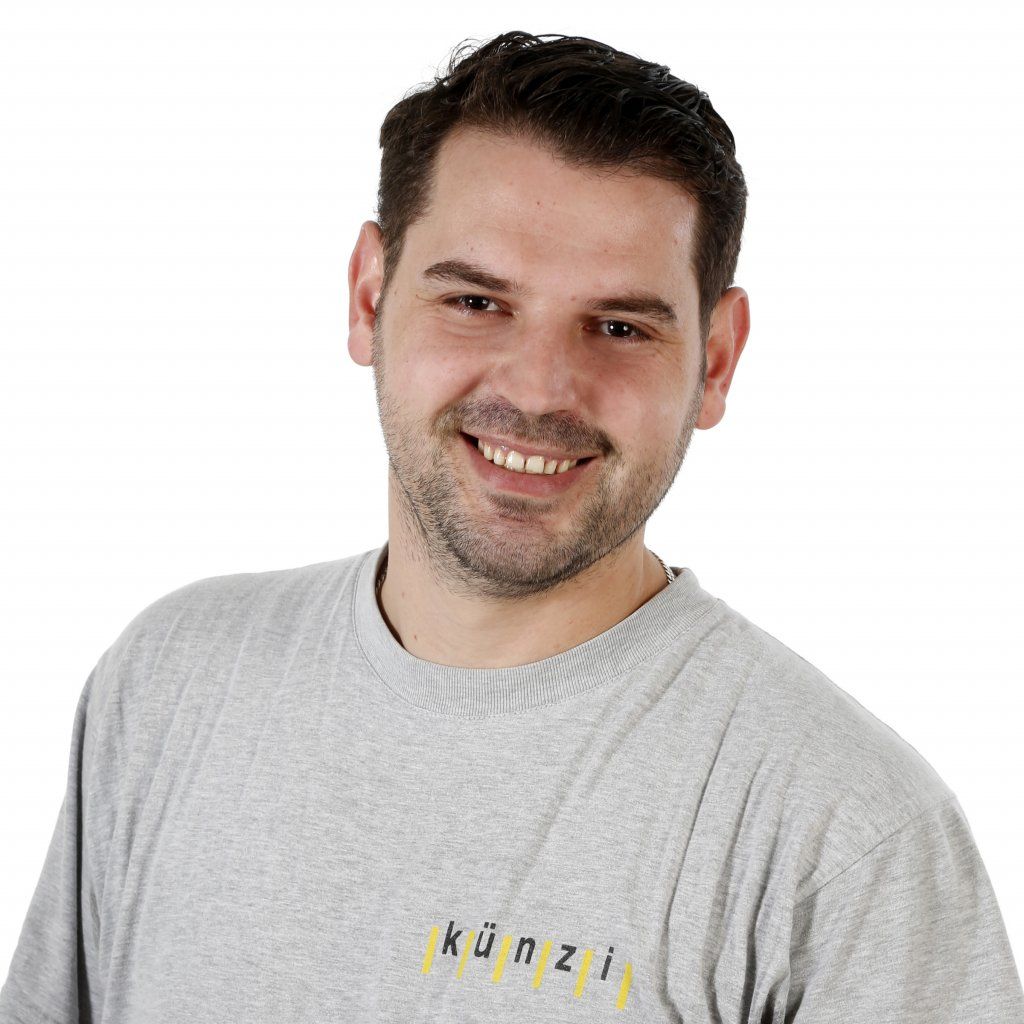 Ein Mann trägt ein graues Hemd mit der Aufschrift 