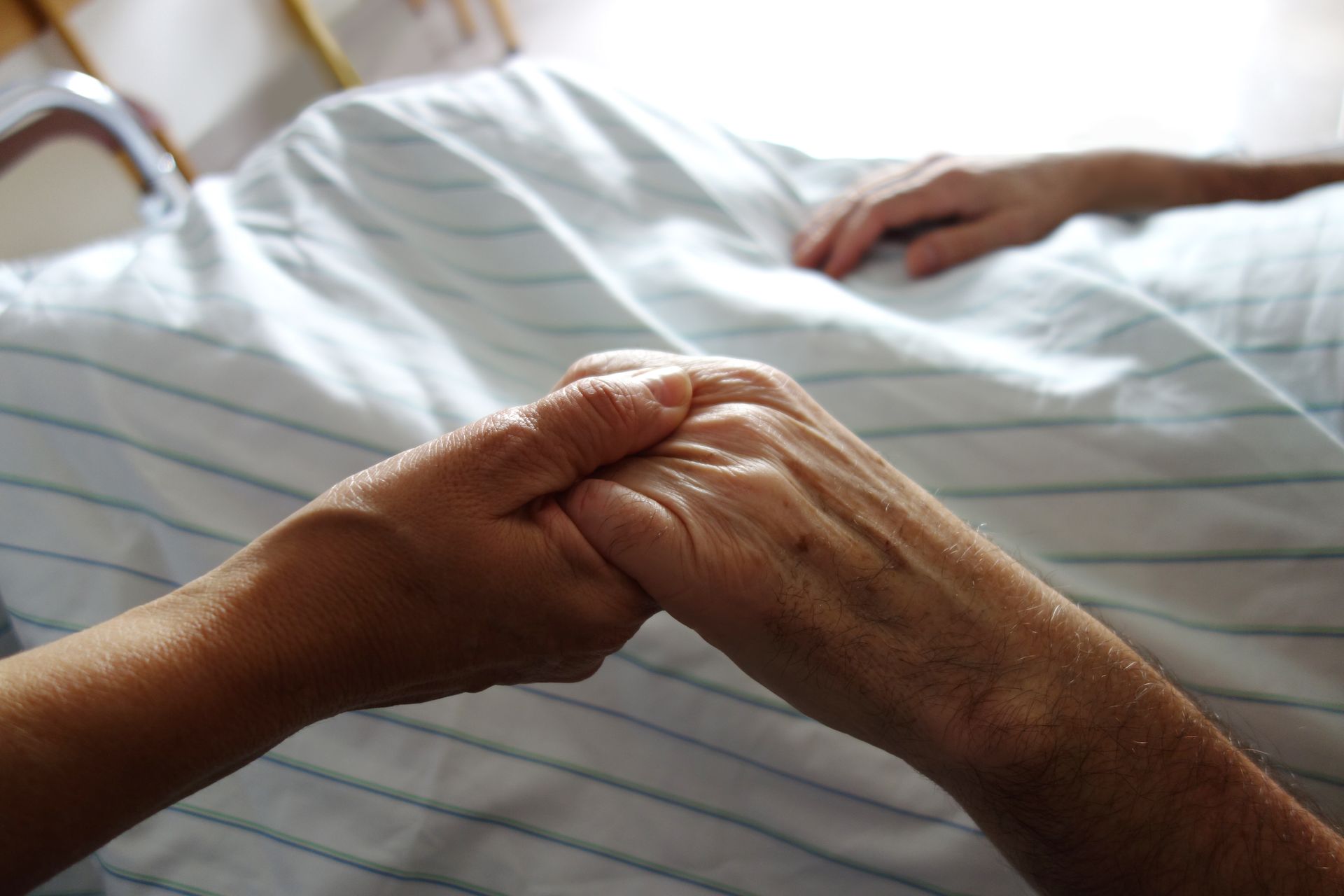 Gros plan sur la main d'une personne âgée tenue par une plus jeune
