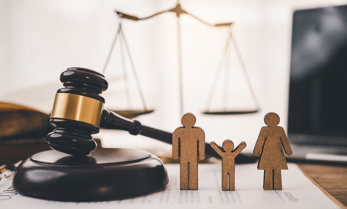 Marteau de la justice avec des silhouettes de personnage pour illustrer la famille
