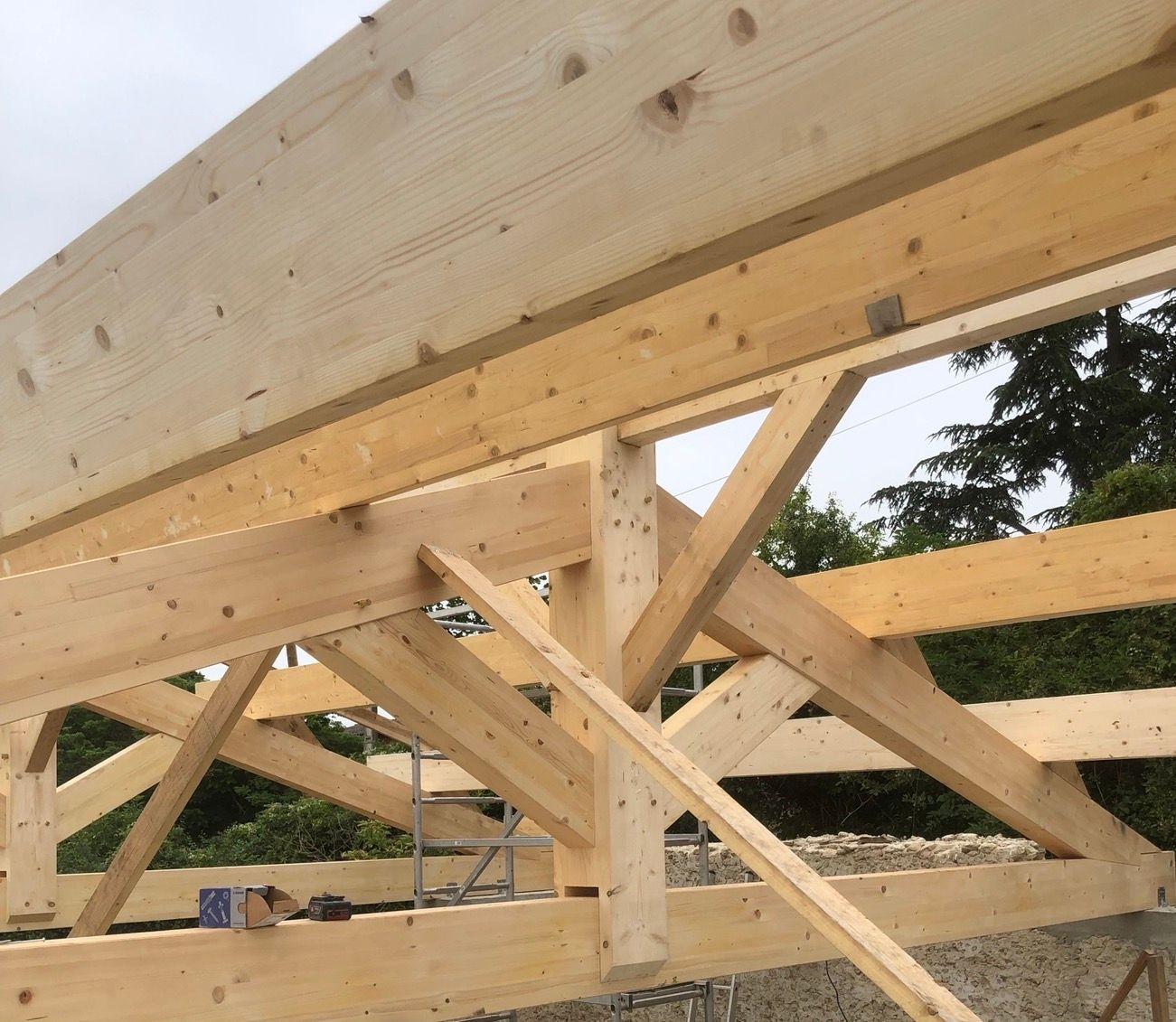Charpente de toit en bois en construction avec poutres entrecroisées.