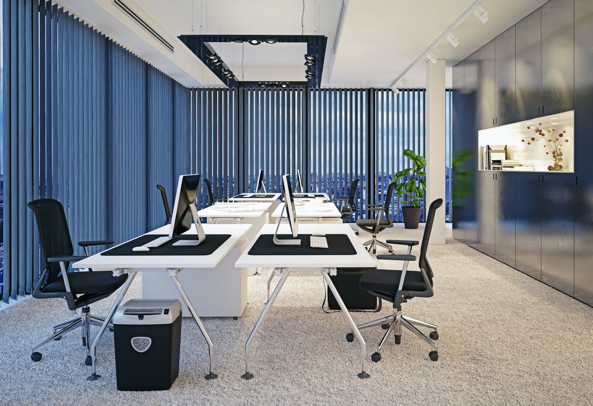 Bureau moderne avec bureaux blancs, chaises noires et grandes fenêtres avec rideaux bleus.