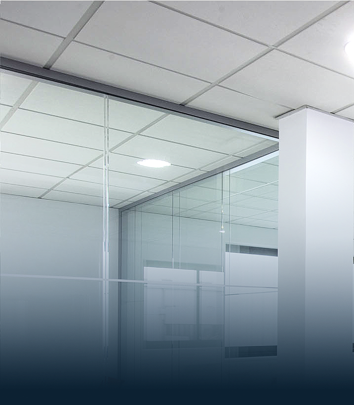 Intérieur de bureau avec murs en verre et plafond suspendu.