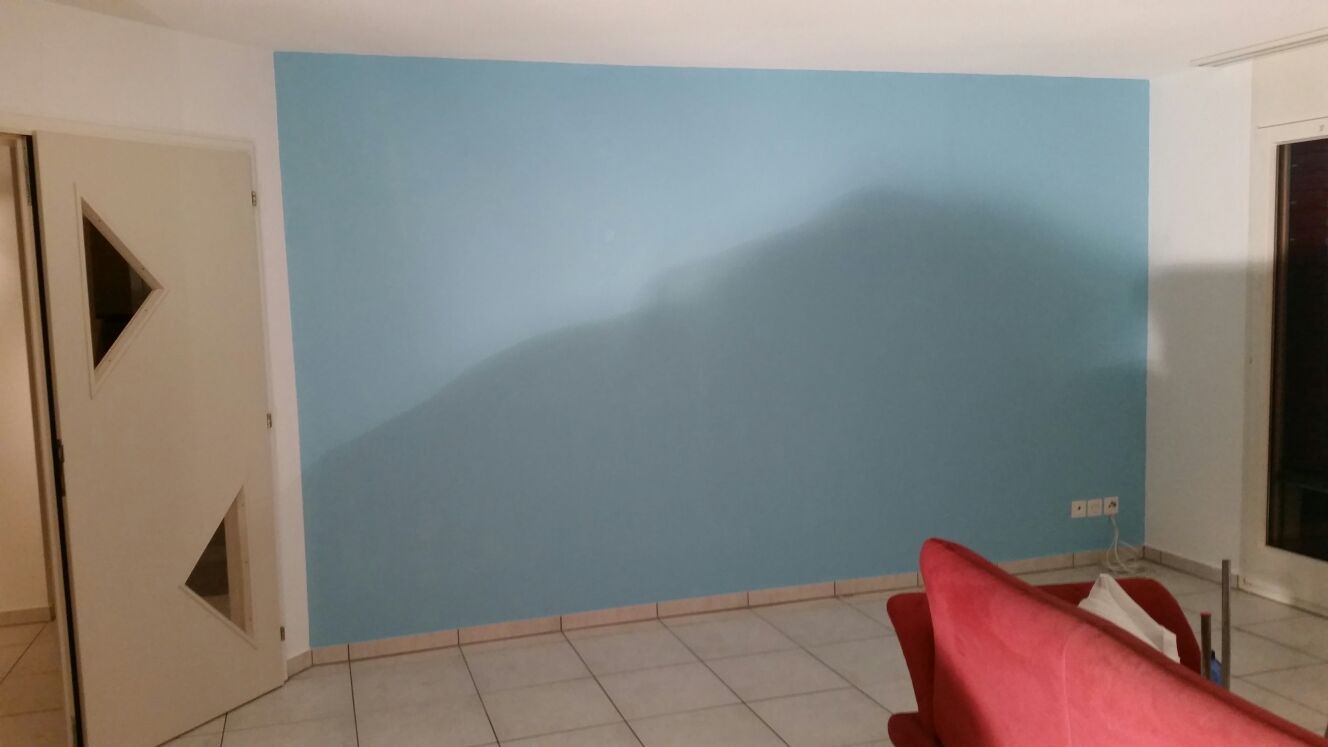 Blaue Akzentwand in einem Zimmer mit weisser Tür und rotem Stuhl.