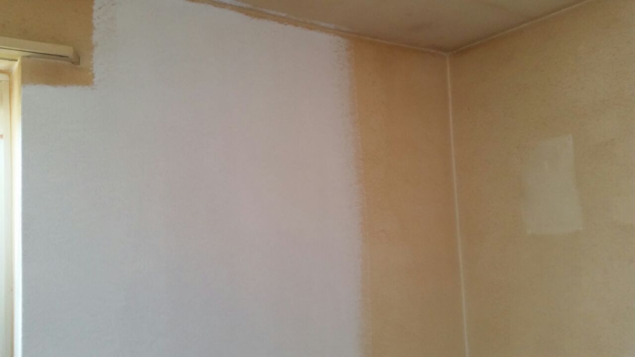 Innenecke eines Zimmers mit zwei Wänden, die in unterschiedlichen Weiss- und Beigetönen gestrichen sind.