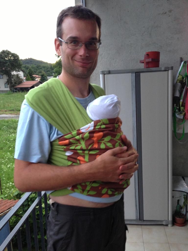 Padre trasporta neonato con fascia porta bebè