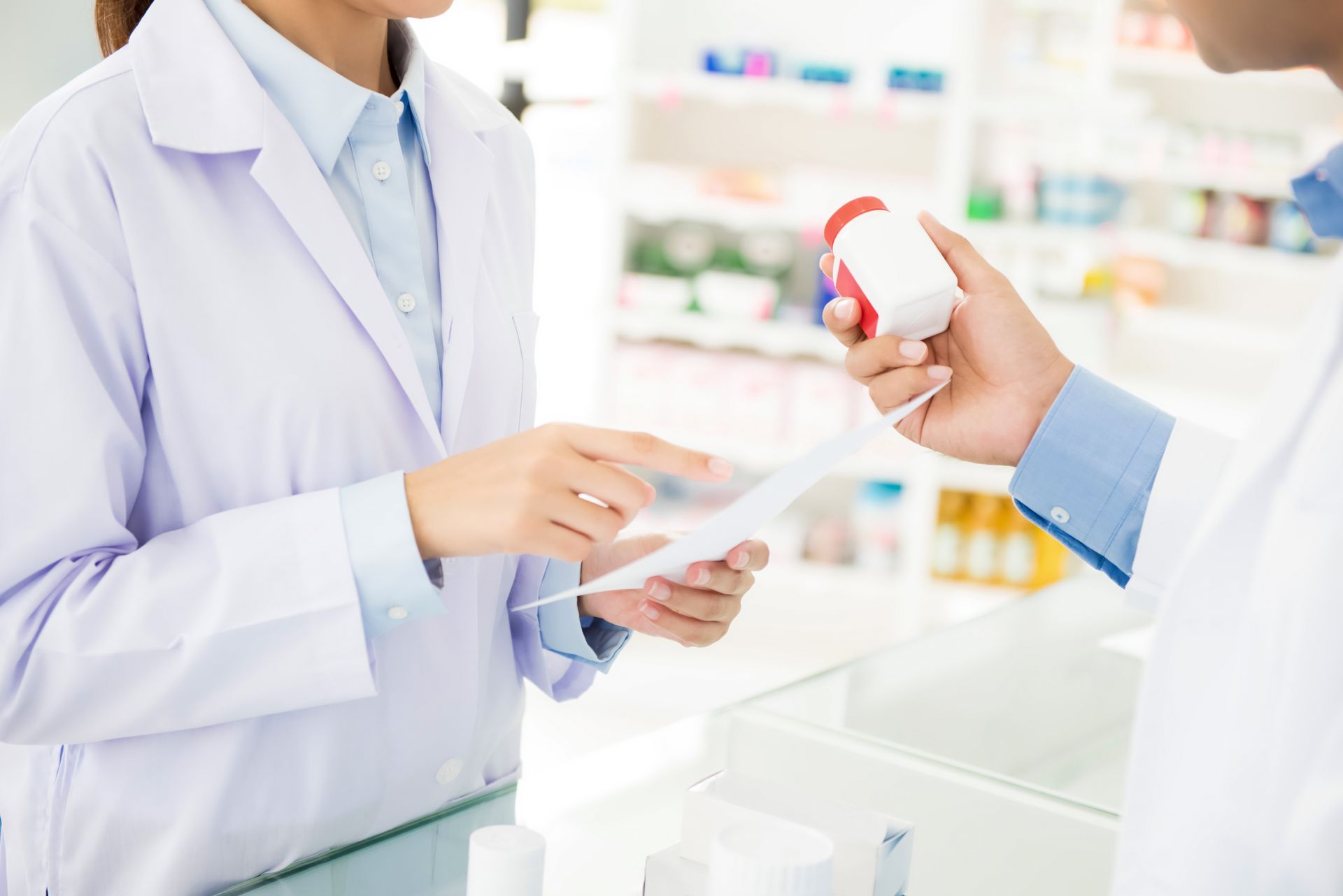 Une pharmacienne et un pharmacien au comptoir.