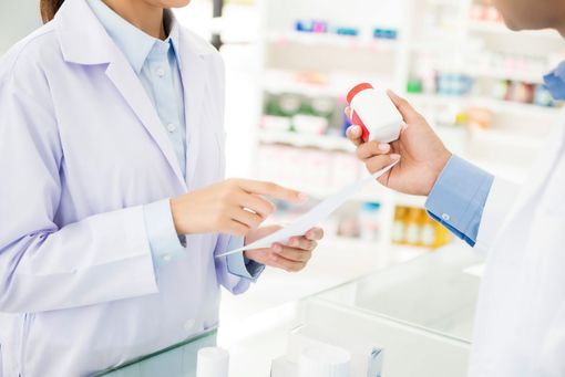 Une pharmacienne et un pharmacien au comptoir.