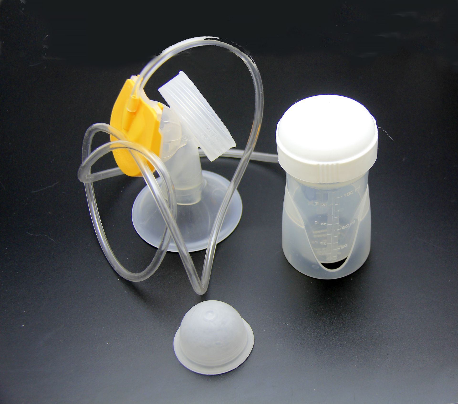 Canule nasale néonatale avec tubulure et petit godet transparent pour médicament sur une surface noire