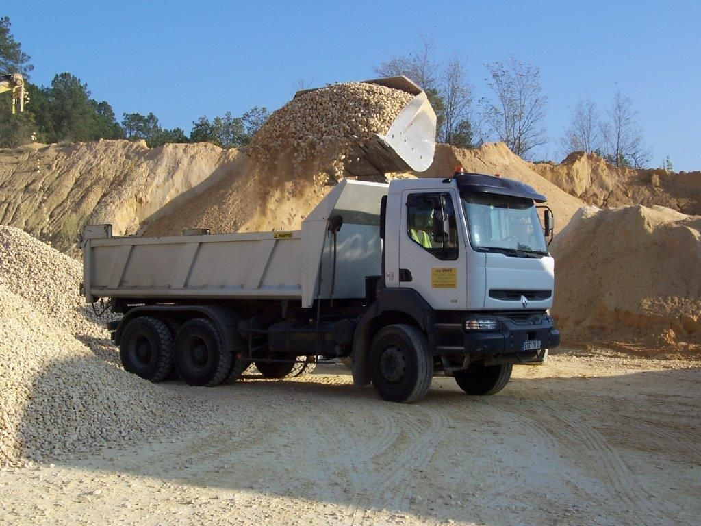 Un camion-benne dans un carrière qui est remplie de sable