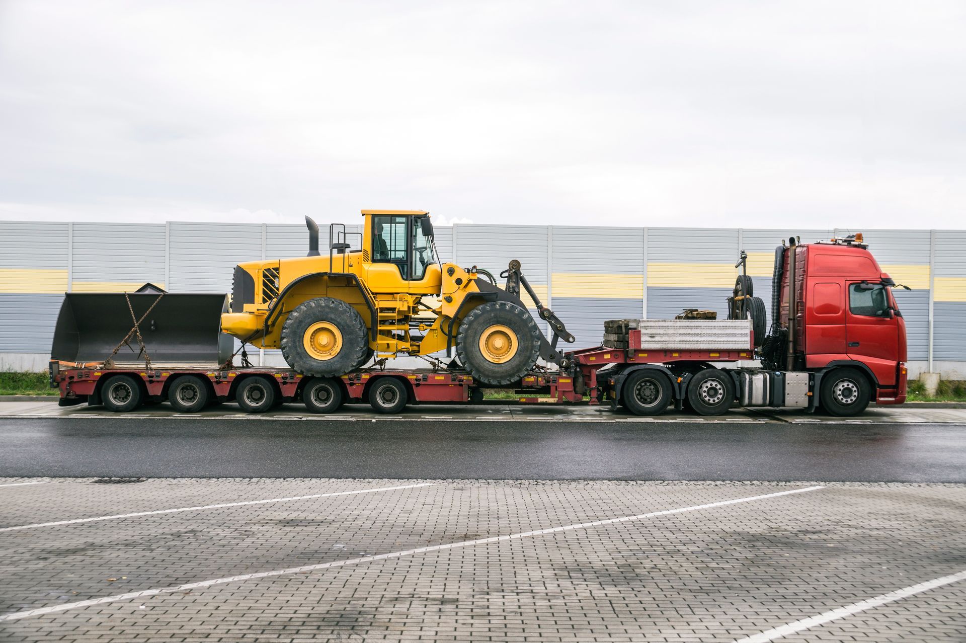 Une tractopelle chargée sur un camion plateau