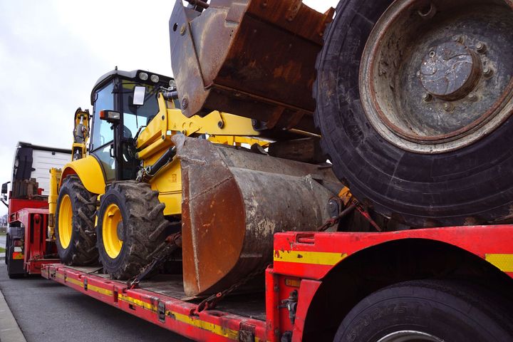 Tractopelle sur un camion plateau