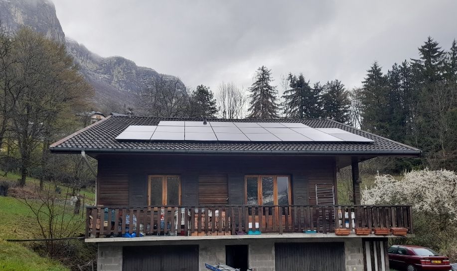 Chalet avec façade en bois et panneaux solaires sur le toit