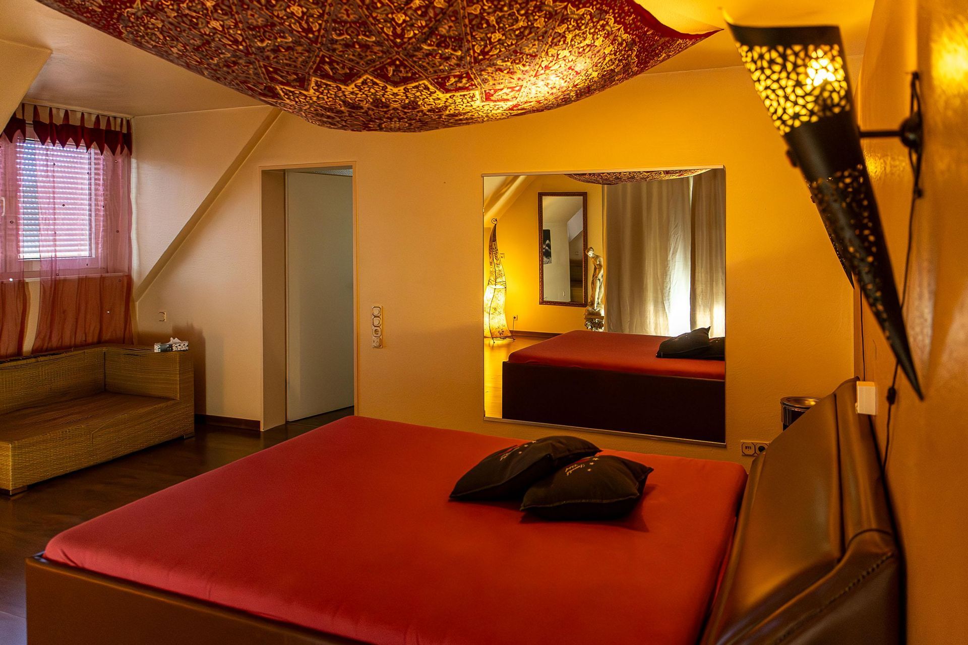 Ein Schlafzimmer mit Bett, Couch und Spiegel.