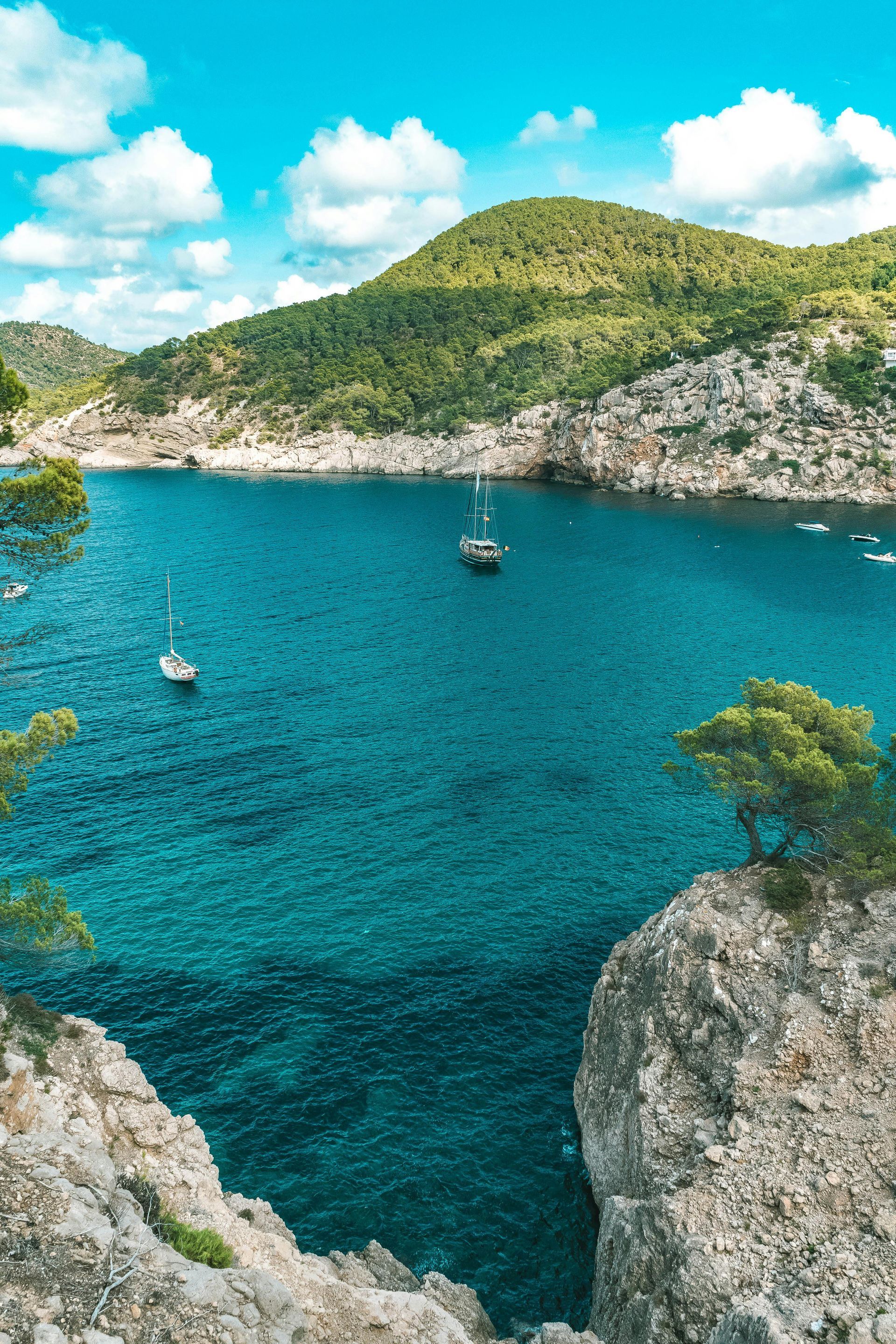 Un gran cuerpo de agua con barcos y montañas al fondo.