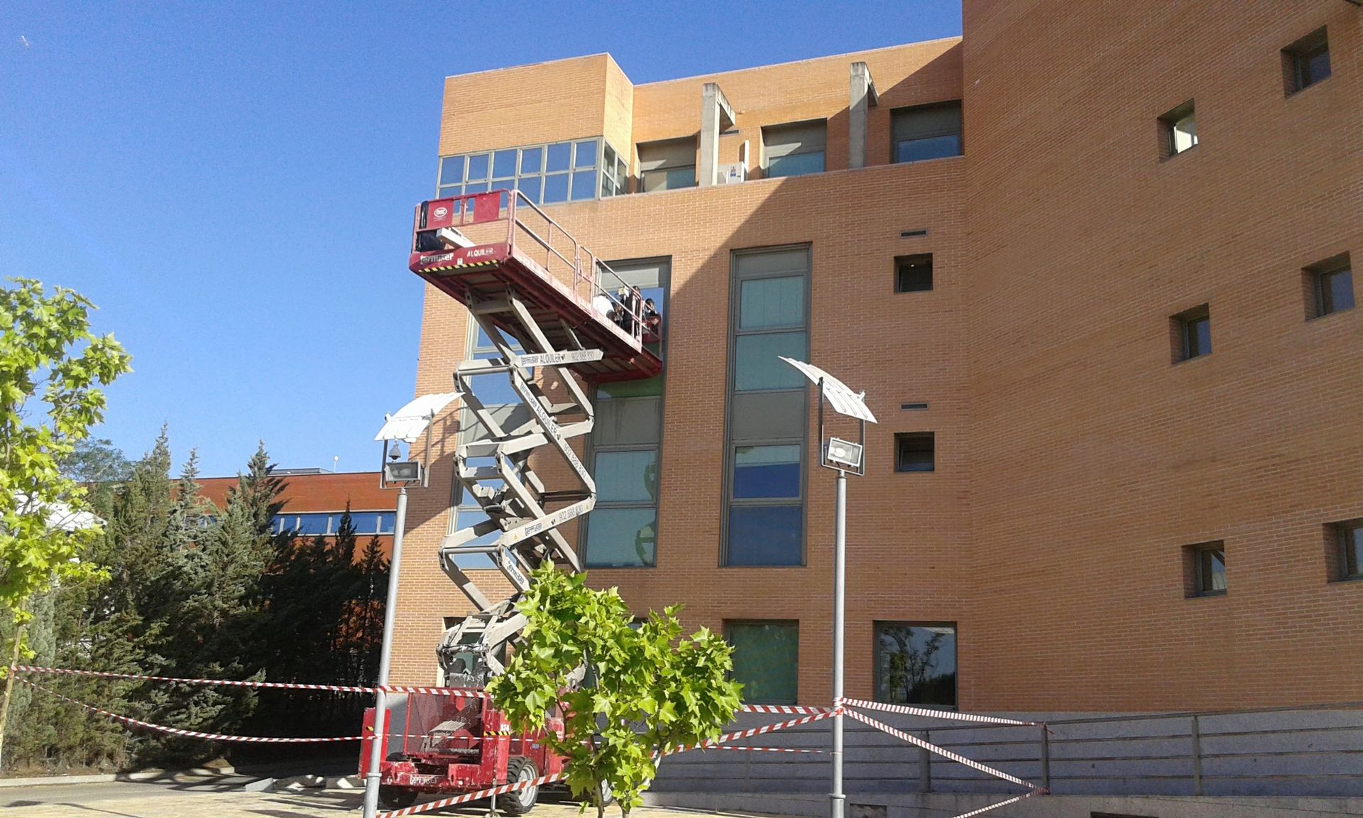Exterior de edificio de hormigón gris con rejilla de ventanas que reflejan el cielo.
