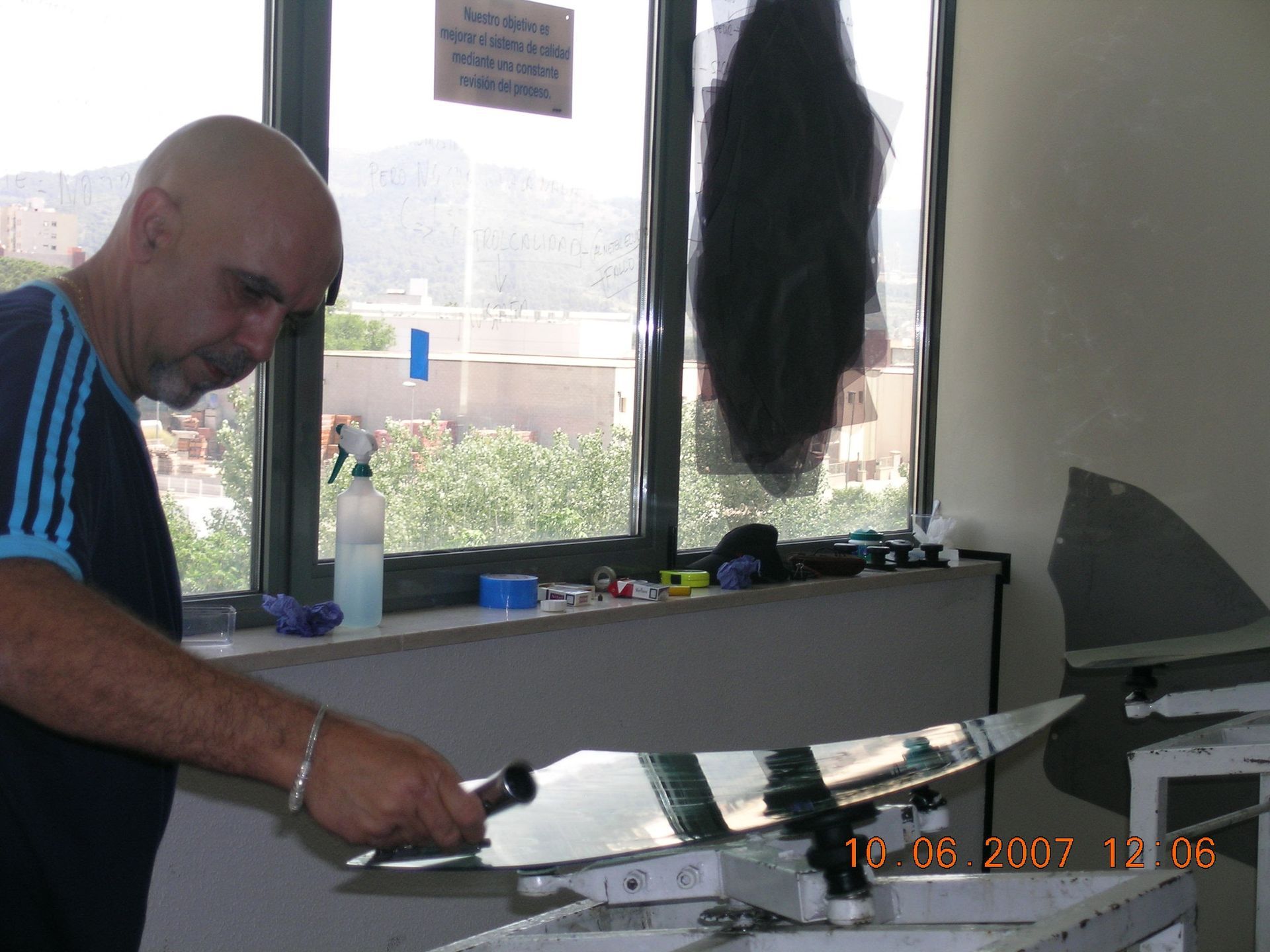 Exterior de edificio de hormigón gris con rejilla de ventanas que reflejan el cielo.
