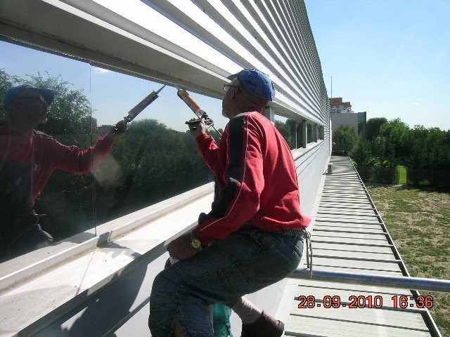 Rascacielos de cristal que refleja el cielo azul y las nubes.