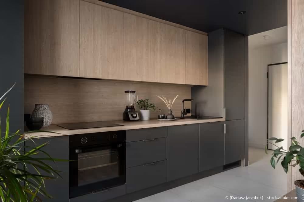 Moderne, minimalistische Küche mit hölzernen Oberschränken, dunklen Unterschränken und Arbeitsplattendekoration
