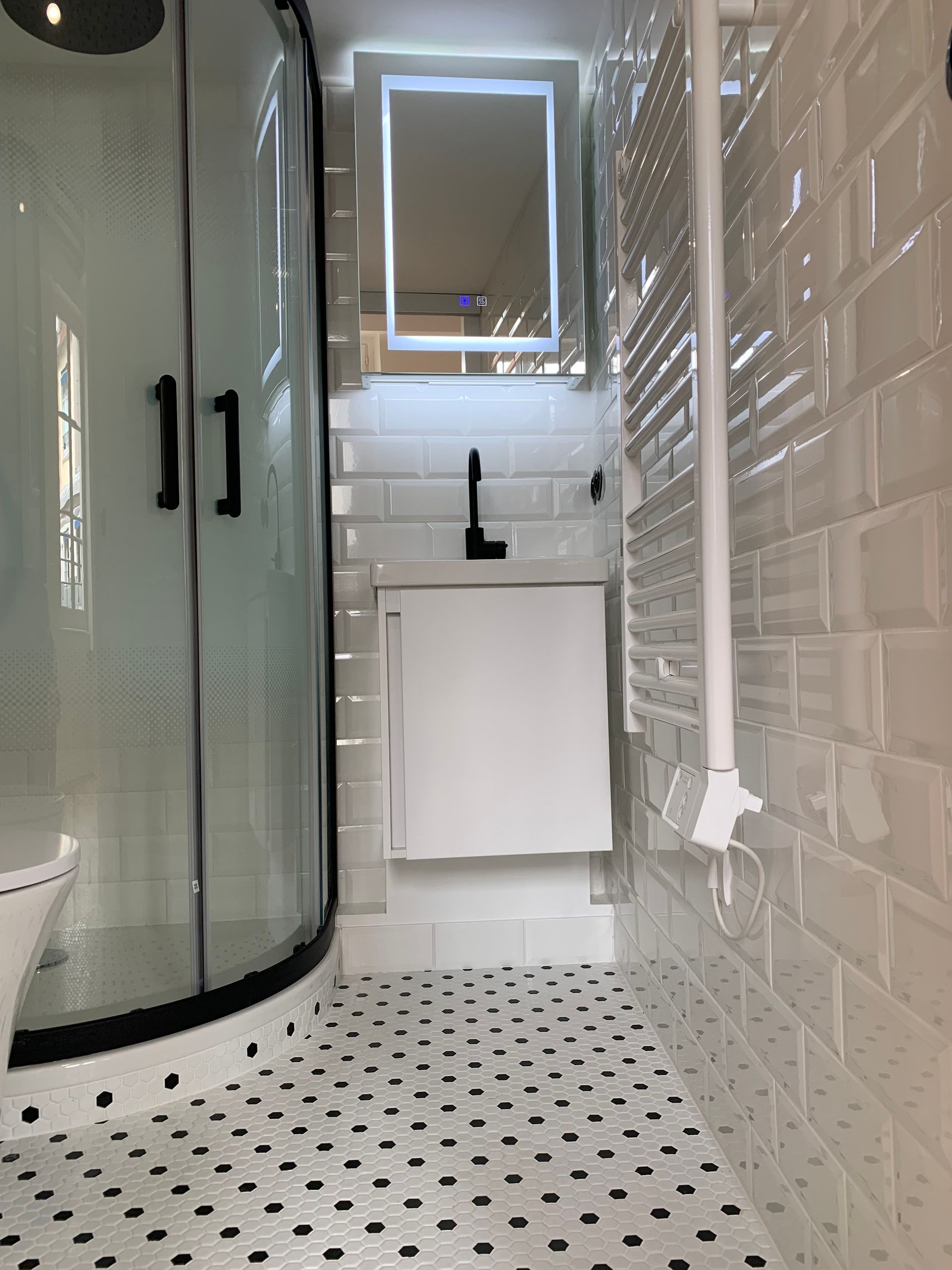 Salle de bains avec douche et petit lavabo