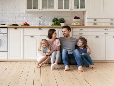 Una familia está sentada en el suelo de una cocina.