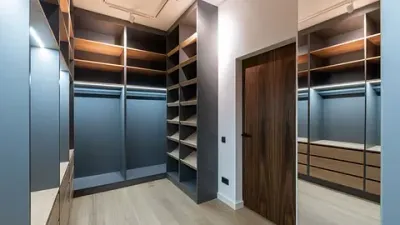 Un vestidor con muchos estantes y un espejo.