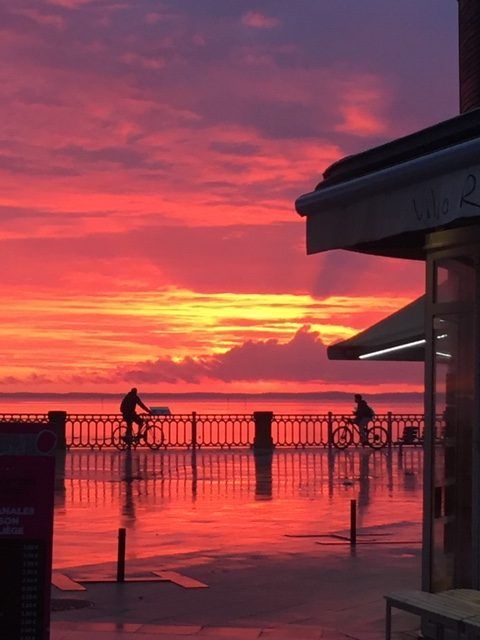Des personnes à vélo face au coucher de soleil