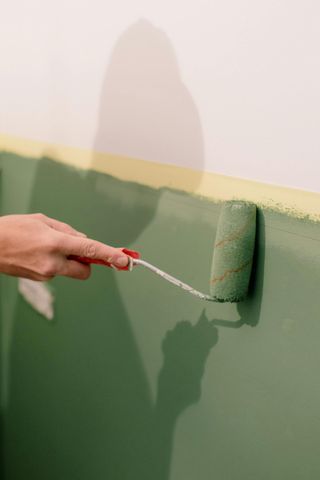 Pièces de CVC comprenant un conduit flexible, des connecteurs métalliques, une grille d'aération circulaire blanche et des pinces disposées sur une surface en bois blanc.