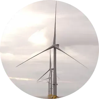 Turbinas de viento que se yerguen altas en un cielo nublado y cubierto.