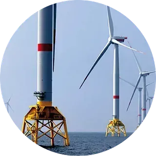 Aerogeneradores marinos en el mar, altas torres grises con palas blancas, sostenidas por estructuras amarillas.
