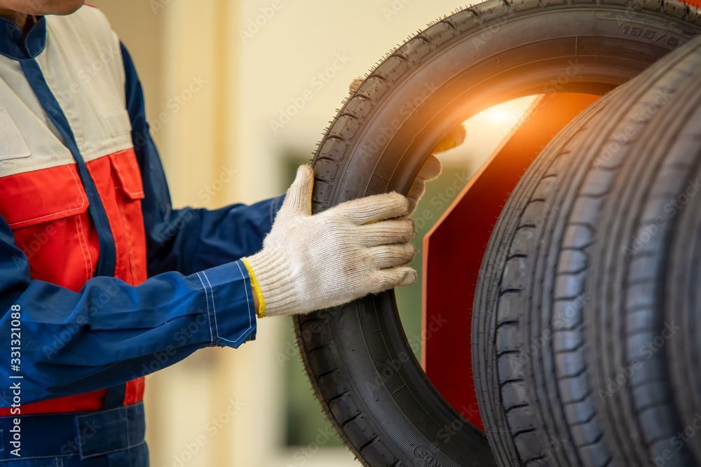 Ein Mann arbeitet in einer Garage an einem Stapel Reifen.