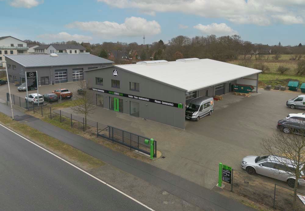 Eine Luftaufnahme eines großen Gebäudes, vor dem viele Autos geparkt sind.