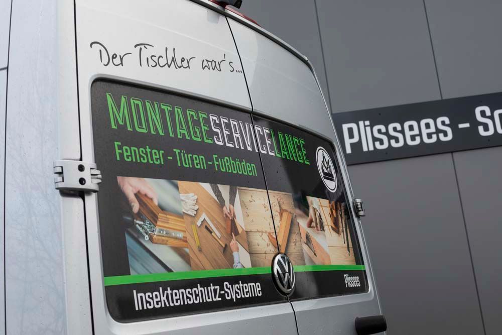 Ein Lieferwagen mit einem Aufkleber auf der Seite, auf dem steht: Montageservice