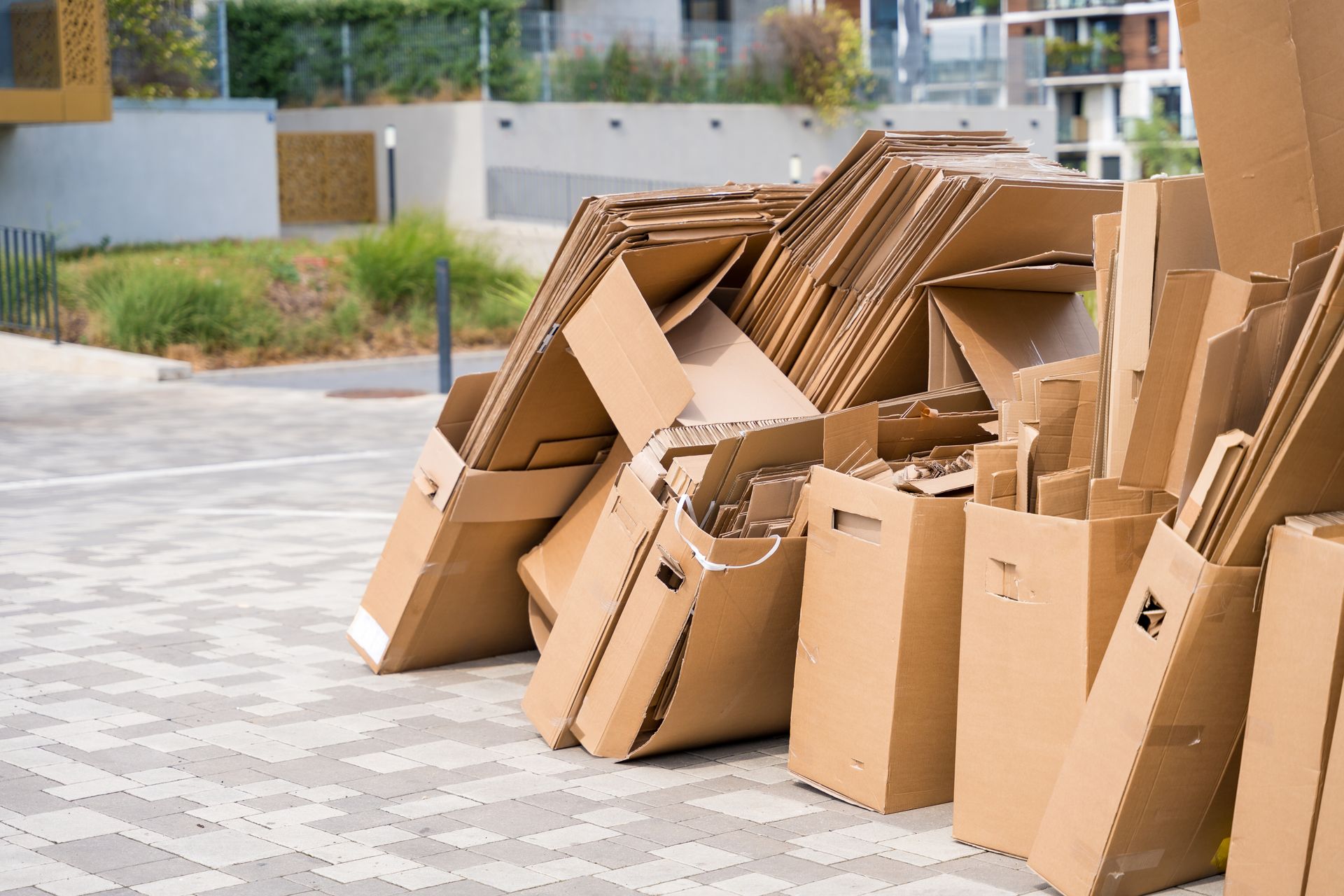 Tas de cartons aplatis dans la rue.