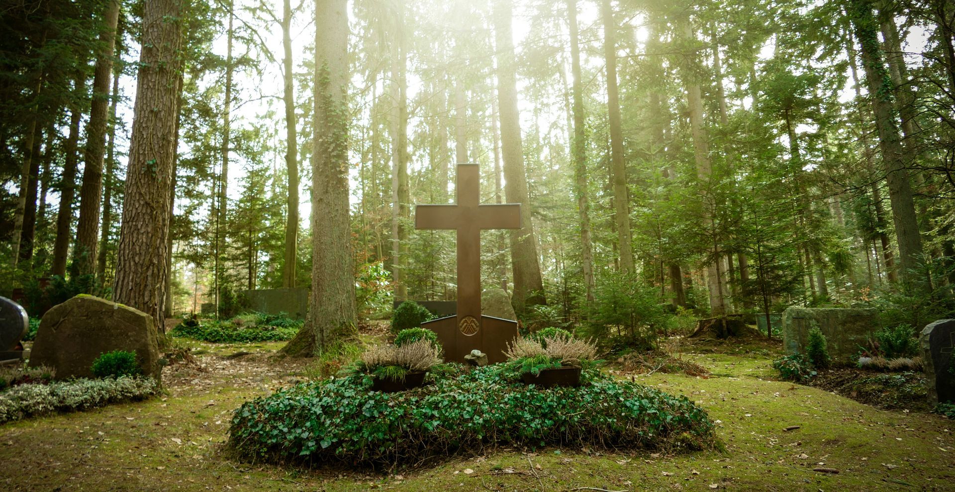 Ein Grab mit Kreuz in einem Wald