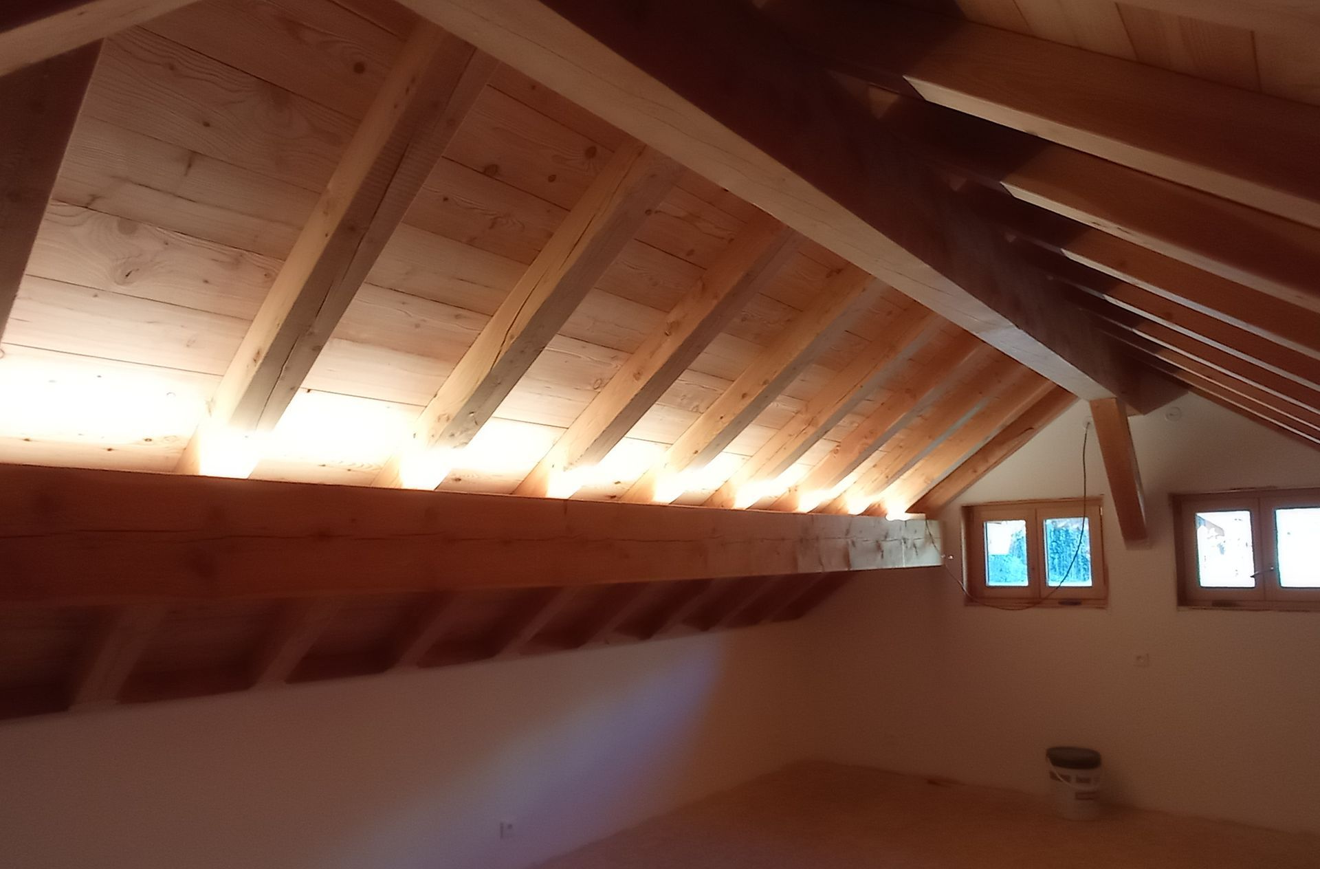 Combles rénovés avec spots allumés et charpente apparente