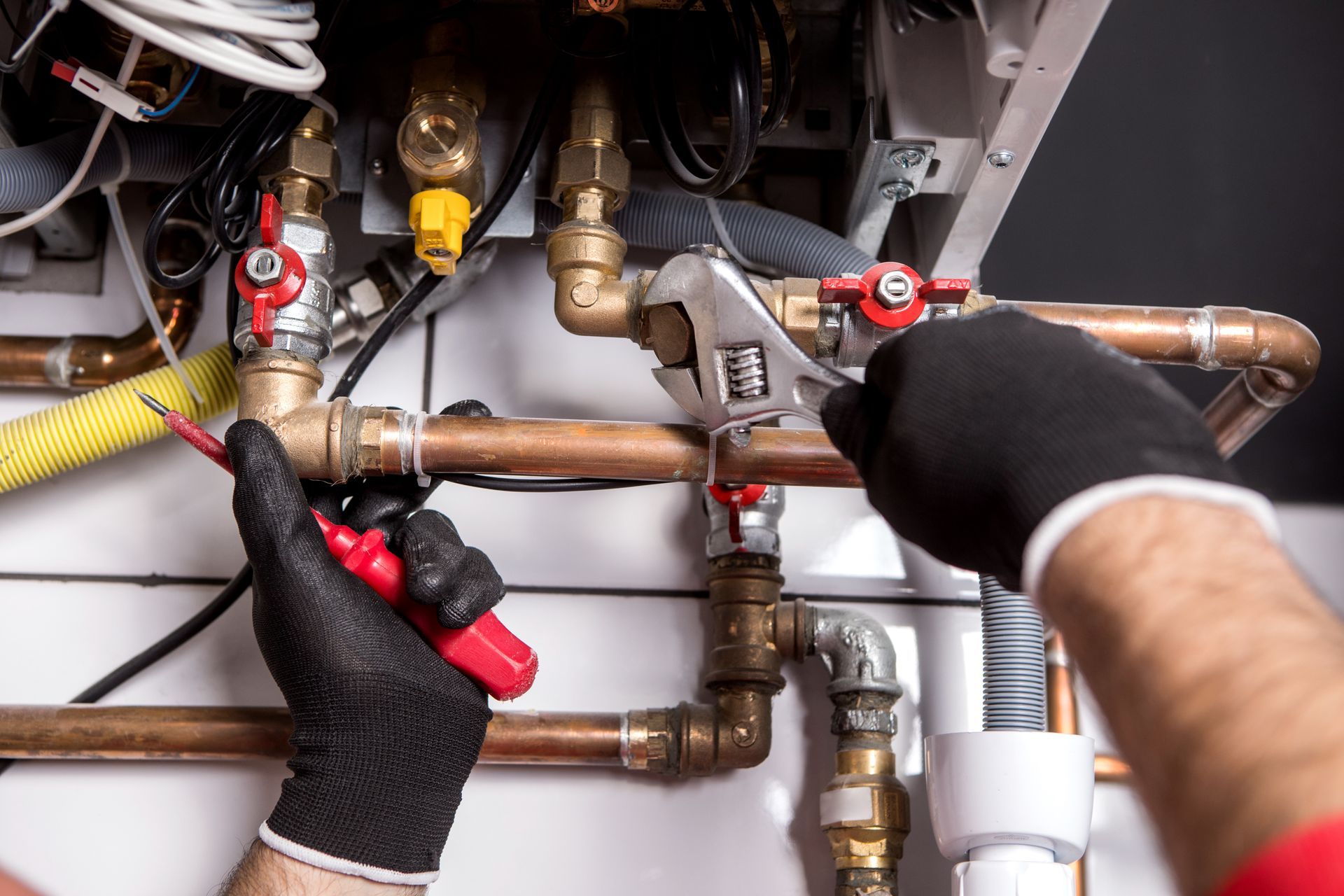 Une personne avec des gants travaillant sur un tuyau