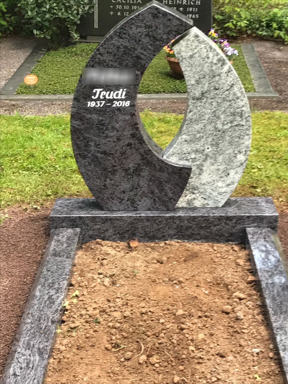 Ein Grabstein mit einer Mondsichel darauf auf einem Friedhof.