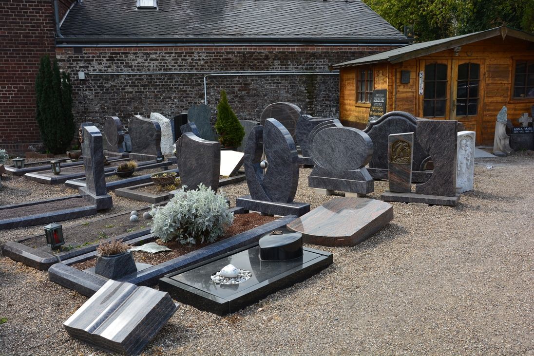Ein Friedhof mit Gräbern und einem Holzgebäude im Hintergrund.