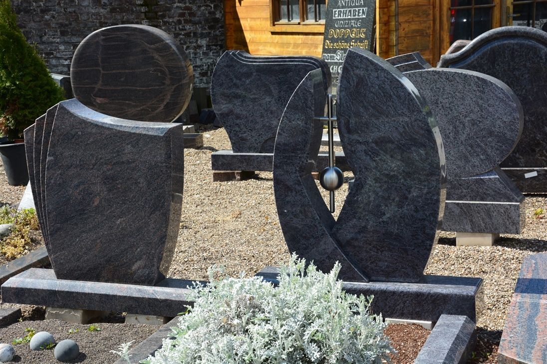 Ein Friedhof mit vielen Gräbern und einem Gebäude im Hintergrund.