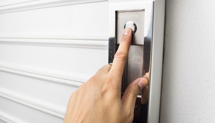 Una persona está presionando un botón en una pared.
