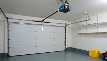 Un garaje con un abridor de puerta de garaje colgando del techo.