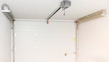 Una puerta de garaje con un abridor de puerta de garaje colgando del techo.