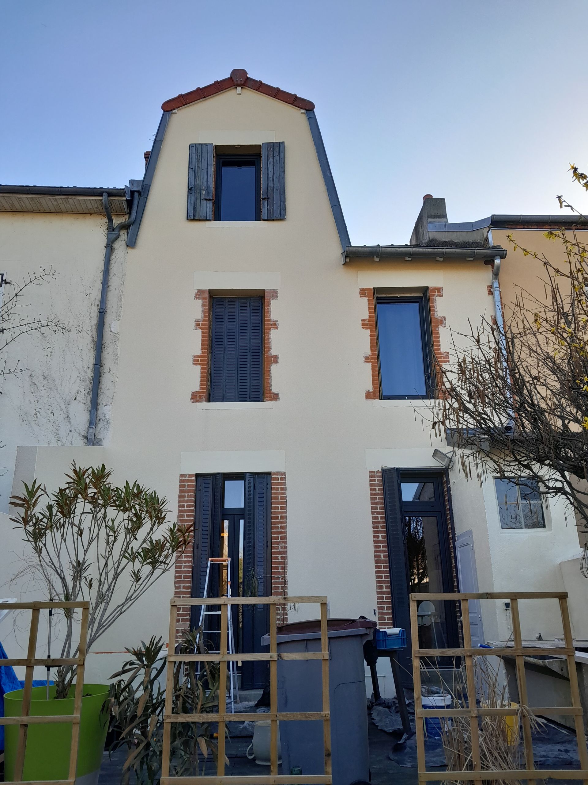 Une maison moderne avec une pelouse, des buissons soigneusement taillés et un garage double.